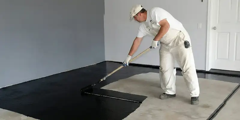 basement waterproofing professional applying waterproof coating to protect a basement floor in Green Bay, WI